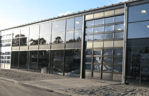 Industriport med stora glaspartier som ger ljusinsläpp i modern fastighet.