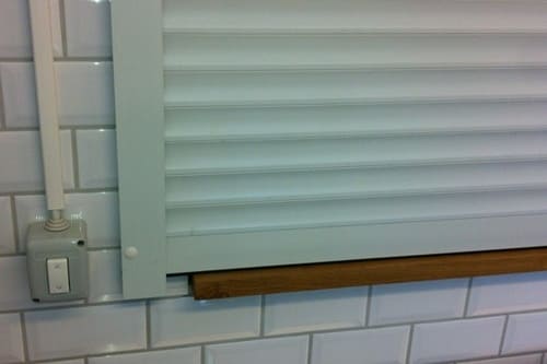 Heltäckande aluminiumjalusi monterad i serveringslucka med knappstyrning.